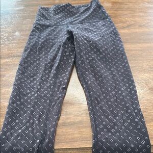 Black Lululemon cropped leggings with Lululemon written on the material size 0